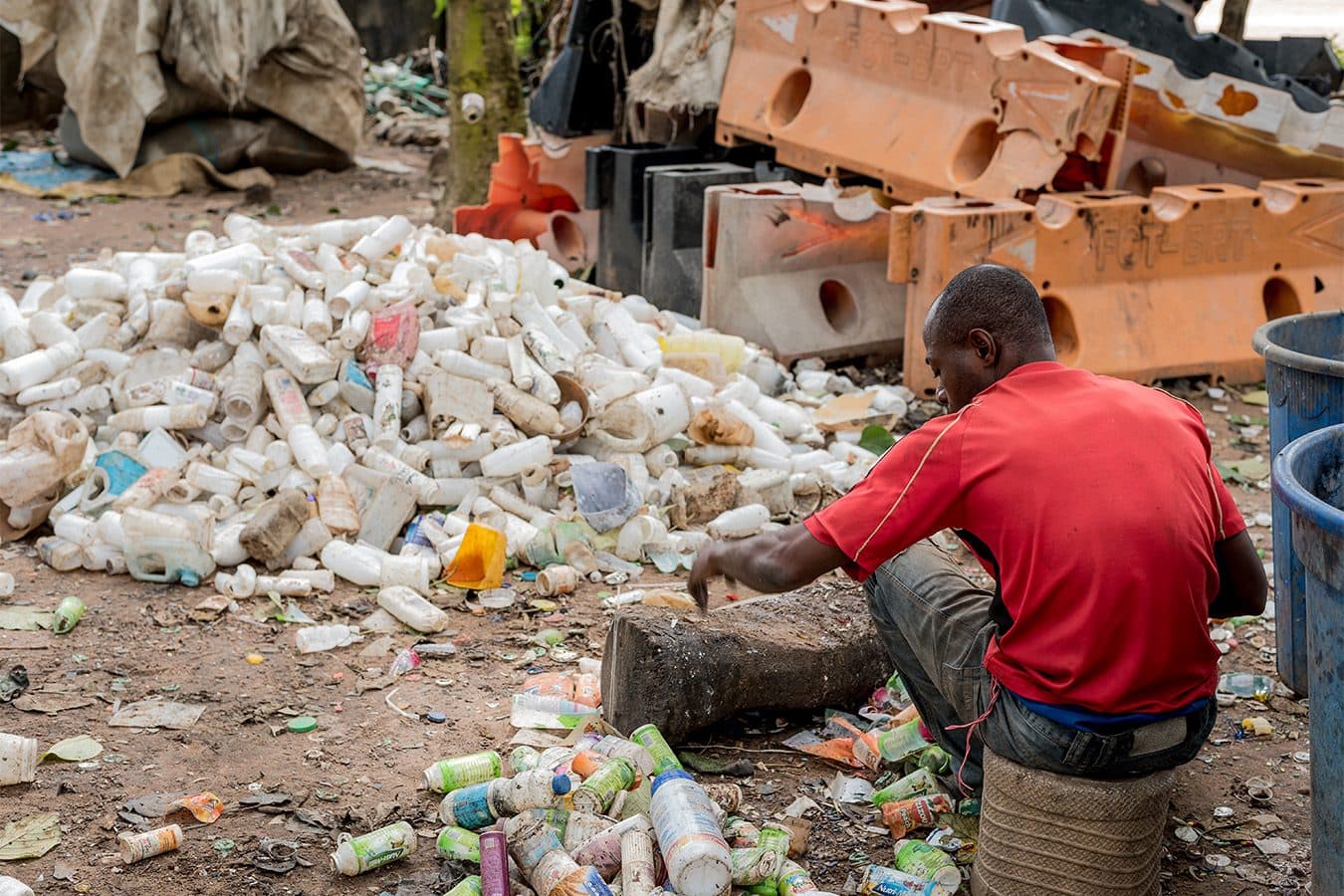 A collector sorting plastic bottles for sale to a recycler